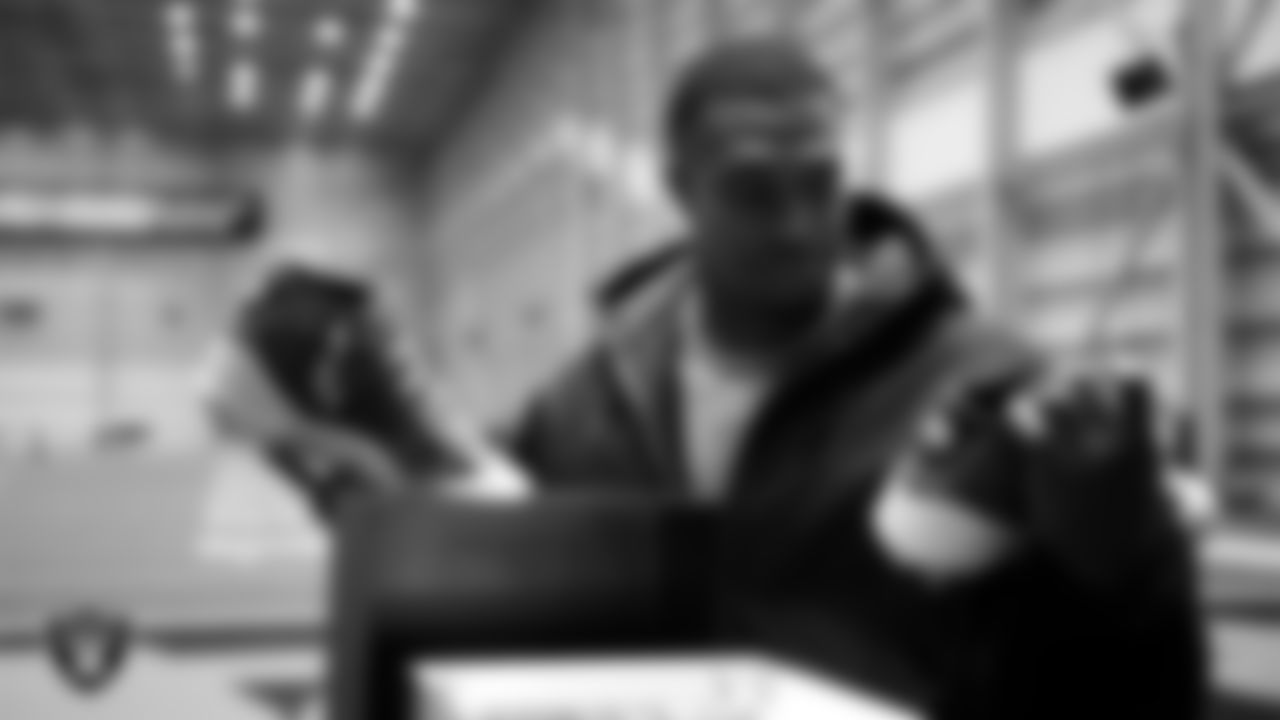 Las Vegas Raiders defensive end Tyree Wilson (9) unboxes his custom cleats for the NFL's My Cause My Cleats initiative at Intermountain Health Performance Center.