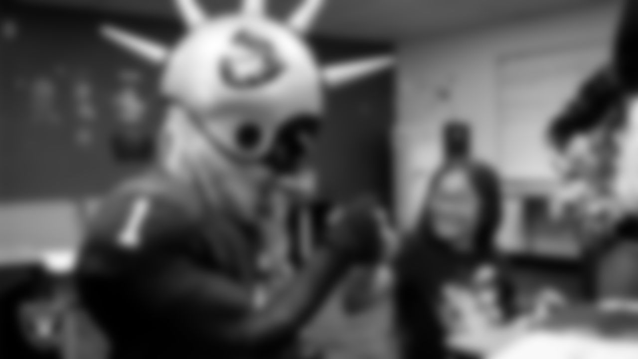 Raider Rusher gives a fist bump to a student during a 'Lil Raiders Pop-Up at Matt Kelly Elementary School.