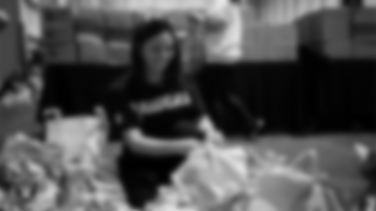 Las Vegas Raiders staff members help pack meals during the Raiders Holiday Meal Packing Party at Intermountain Health Performance Center.