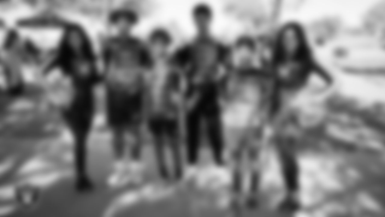 Raiderettes Kylee and Sloane pose for a photo with athletes during the LEEAP Flag Football Tournament at Desert Breeze Park.