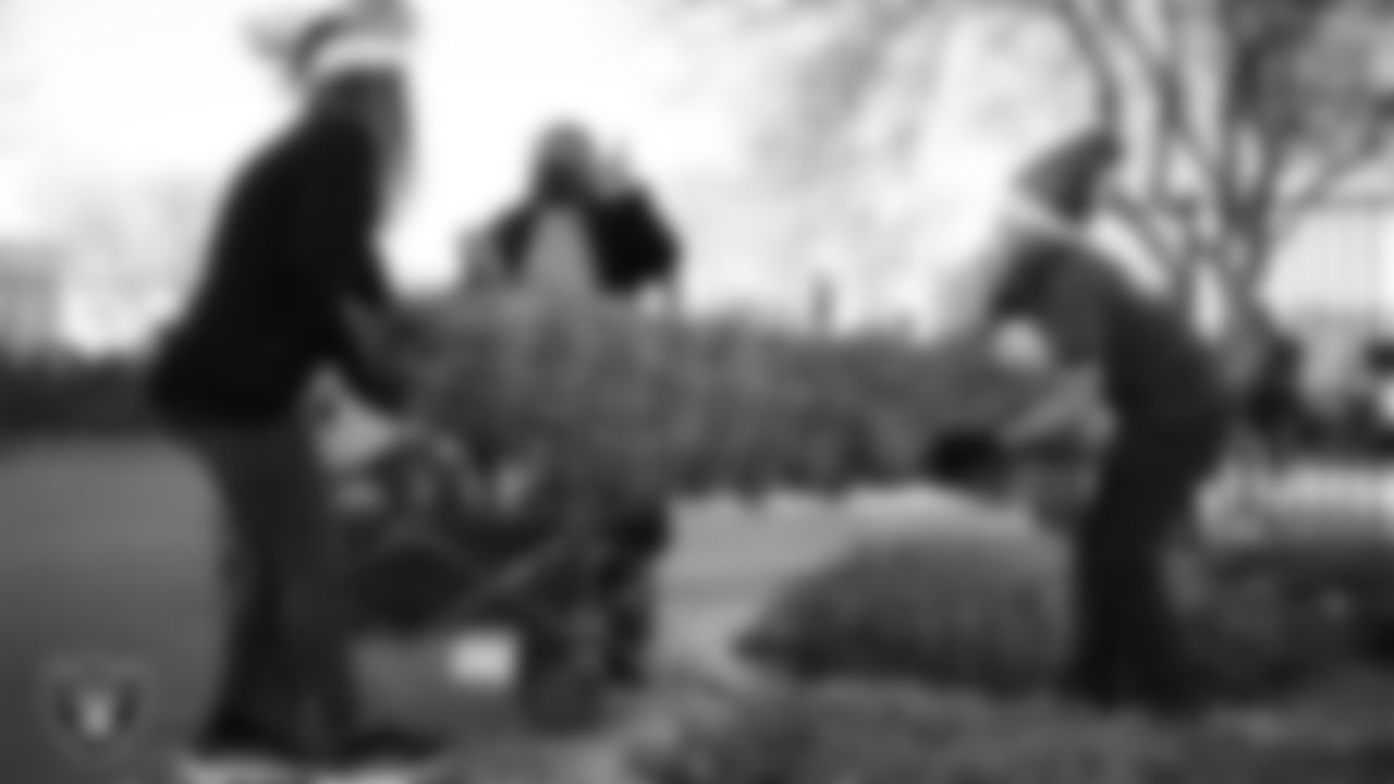 Air Force members and their families pick out a tree during the Raiders Holiday Salute at Nellis Air Force Base - Coral Academy.