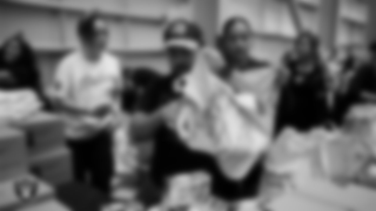 Las Vegas Raiders staff members help pack meals during the Raiders Holiday Meal Packing Party at Intermountain Health Performance Center.