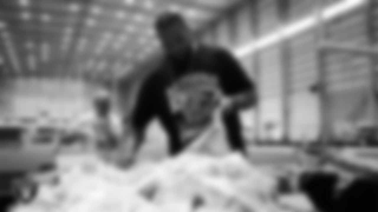 Las Vegas Raiders staff members help pack meals during the Raiders Holiday Meal Packing Party at Intermountain Health Performance Center.