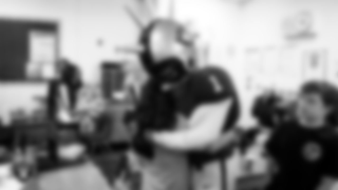 Raider Rusher hugs a student during a 'Lil Raiders Pop-Up at Richard H. Bryan Elementary School.