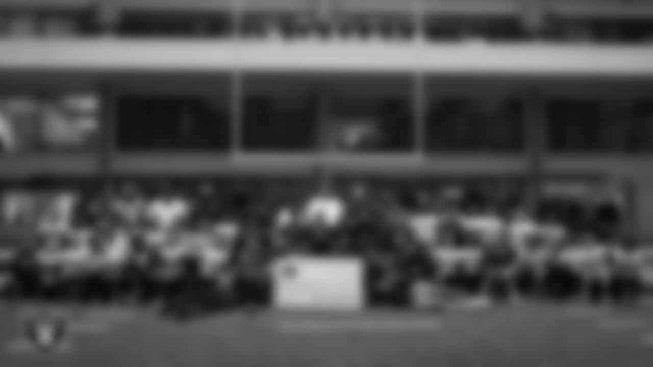 Athletes pose for a photo after receiving a check to go towards their travels for nationals during an open practice at Intermountain Health Performance Center.
