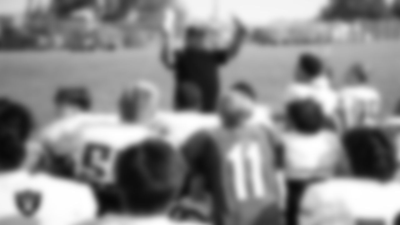 Las Vegas Raiders senior manager of football development Jordan Aguilar presents the SLAM! Academy football team with new gloves during practice at SLAM! Academy.