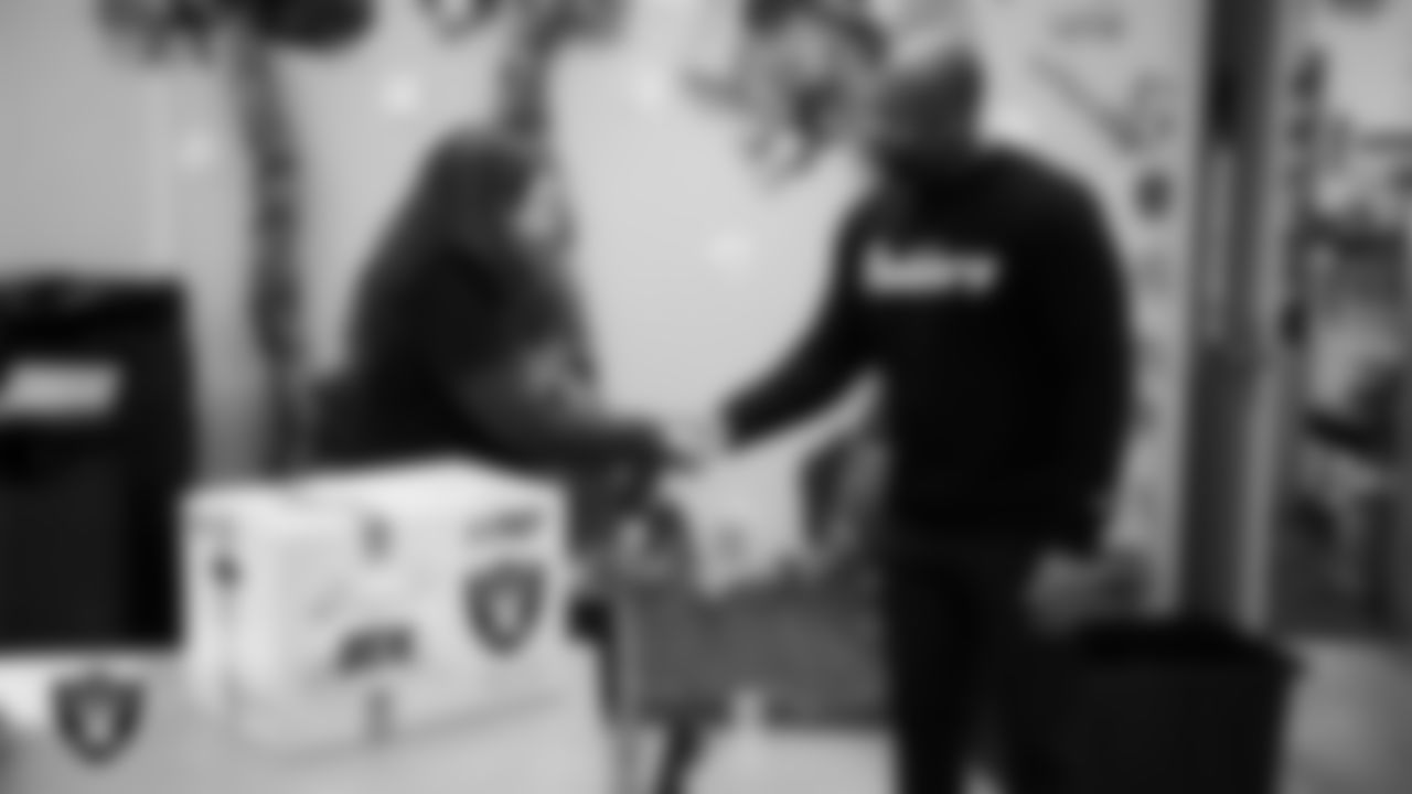 Las Vegas Raiders senior director of football development Myles Hayes presents a teacher with a classroom gift box during a Raiders Spirit Day at Richard H. Bryan Elementary School.