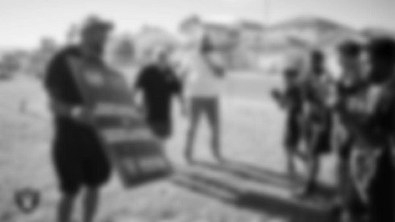 Las Vegas Raiders alumnus Korey Toomer presents the Clifford J. Lawrence Junior High School flag football team with an award after winning a matchup against Walter Johnson Junior High School.