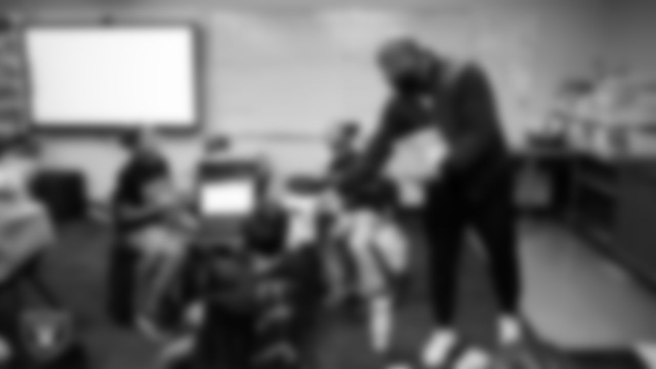 Las Vegas Raiders senior director of football development Myles Hayes hands out stickers to students at Matt Kelly Elementary School.