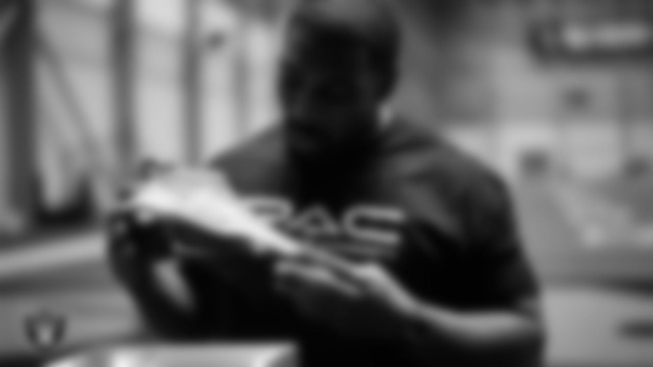 Las Vegas Raiders defensive tackle Thomas Booker IV (99) unboxes his custom cleats for the NFL's My Cause My Cleats initiative at Intermountain Health Performance Center.