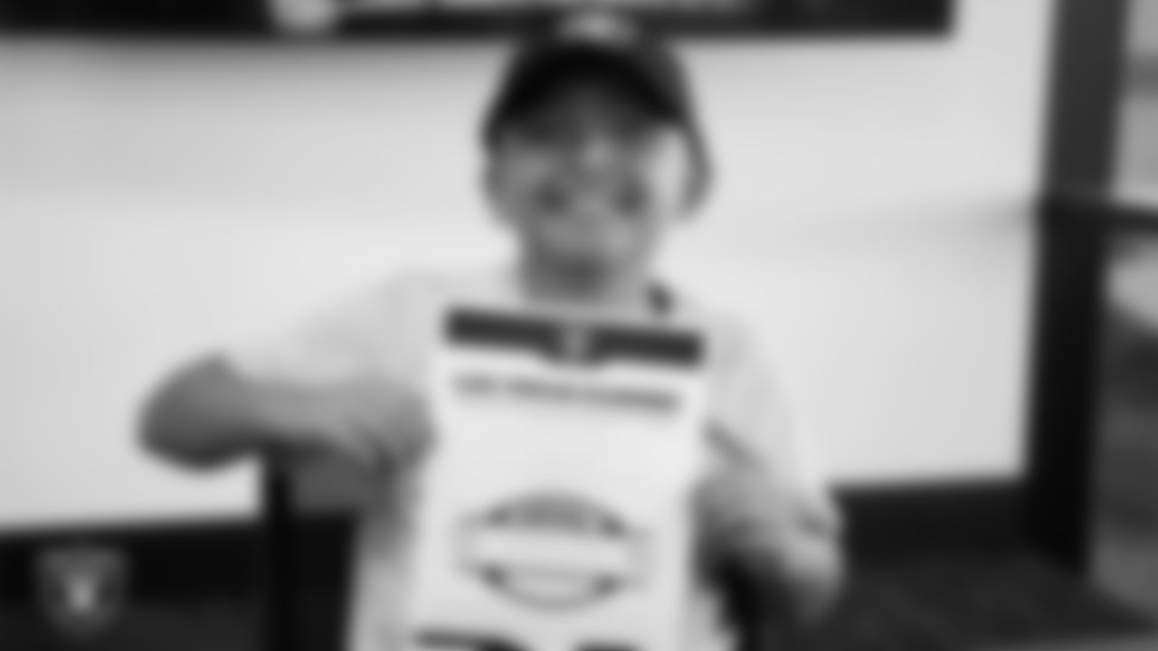 Christopher Arias from Make-A-Wish shows off his honorary Raider contract in the Ubeo press conference room during a visit to Intermountain Health Performance Center.