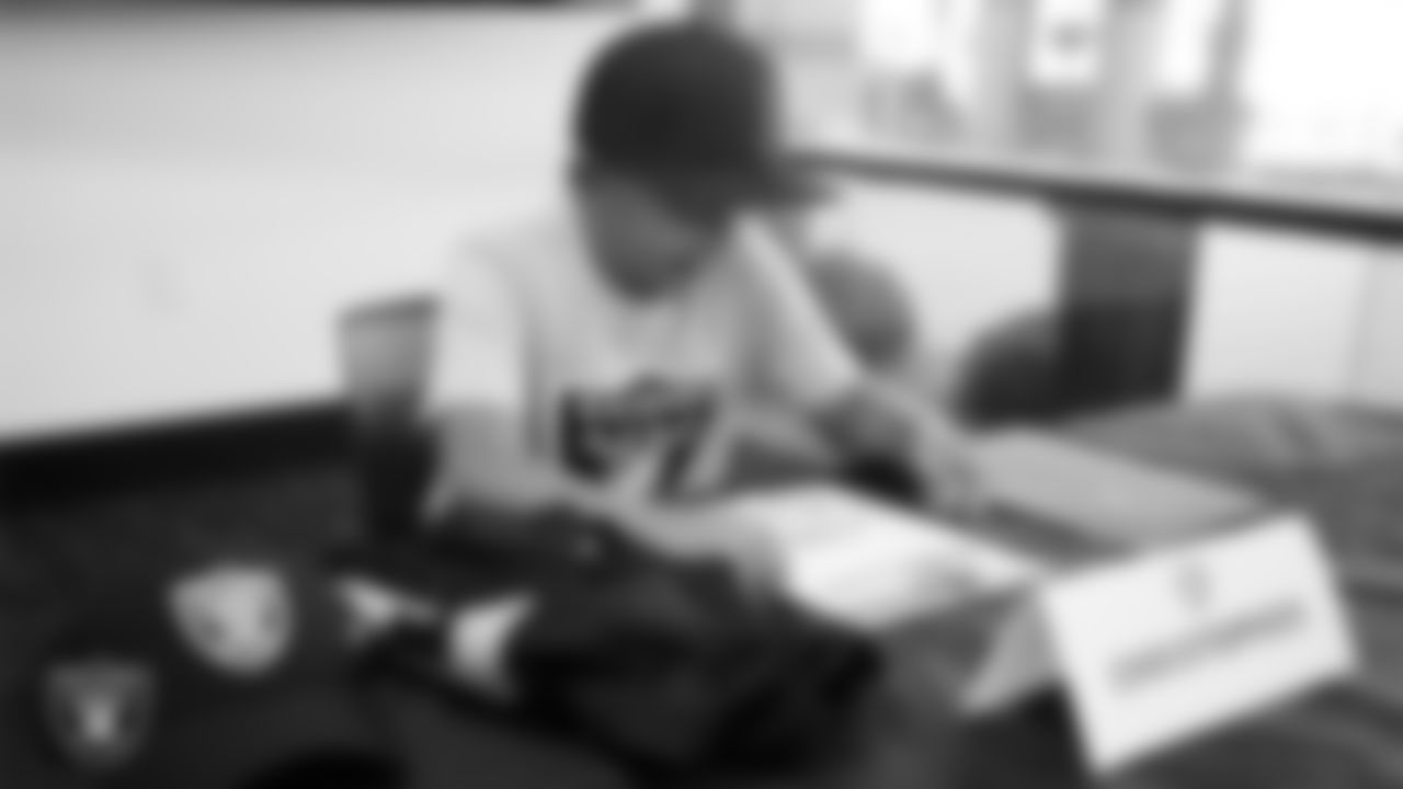 Christopher Arias from Make-A-Wish signs an honorary Raider contract in the Ubeo press conference room during a visit to Intermountain Health Performance Center.