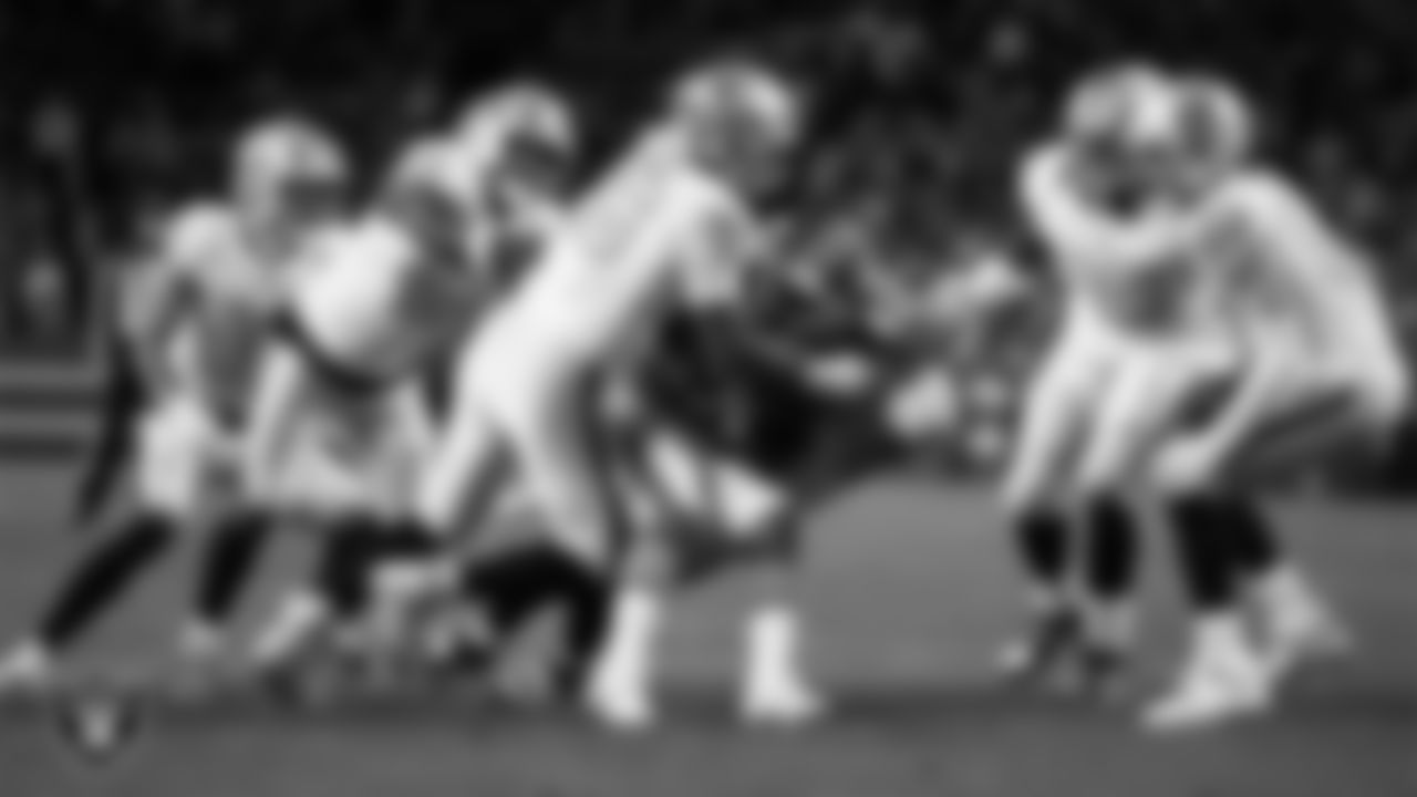 Las Vegas Raiders defensive tackle Jonah Laulu (96) and safety Jeremy Chinn (11) make a tackle during the regular season away game against the Denver Broncos at Empower Field at Mile High.
