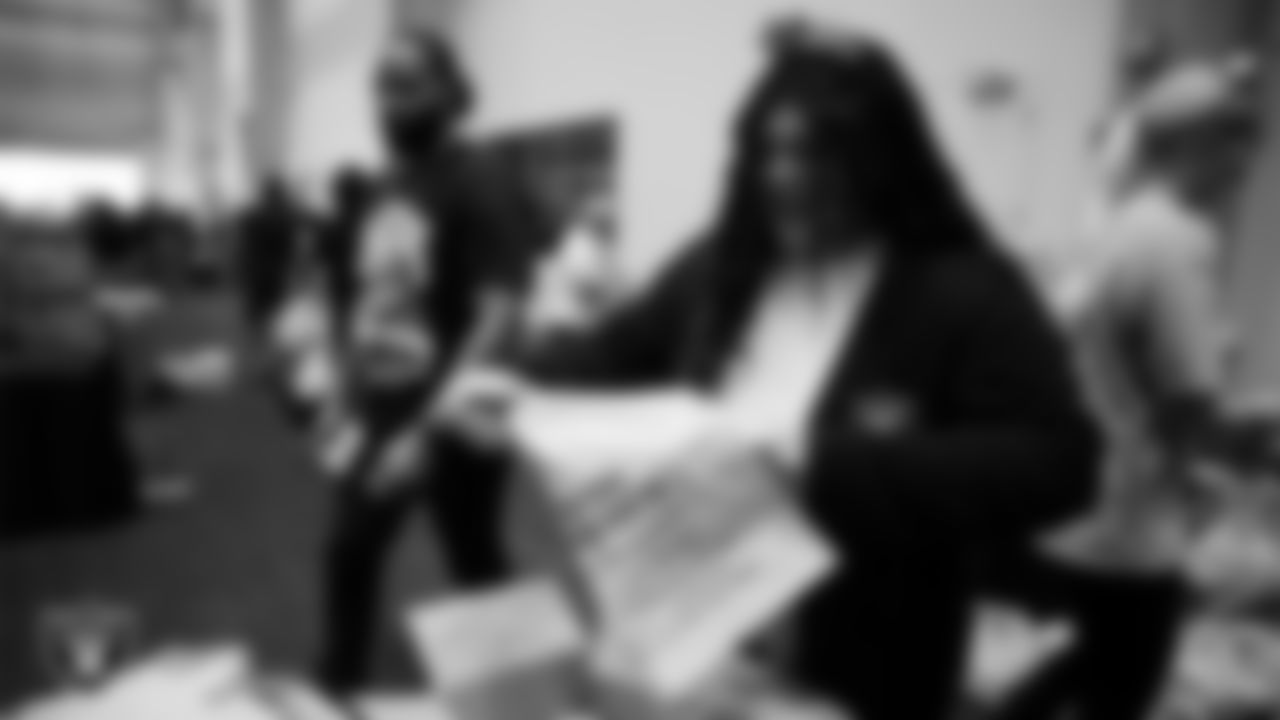 Las Vegas Raiders staff members help pack meals during the Raiders Holiday Meal Packing Party at Intermountain Health Performance Center.