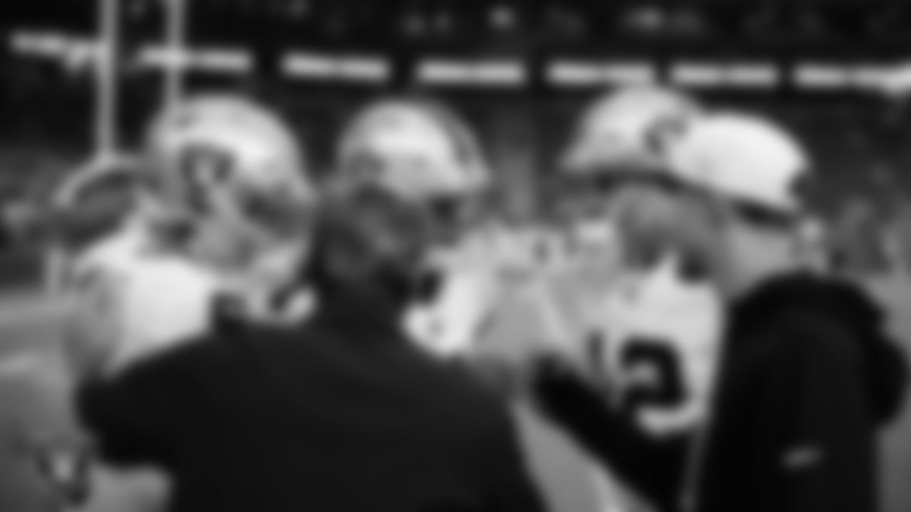 The Las Vegas Raiders quarterbacks and quarterbacks coach Greg Olson and assistant quarterbacks coach/game manager Nate Carroll huddle before the preseason away game against the Arizona Cardinals at State Farm Stadium.