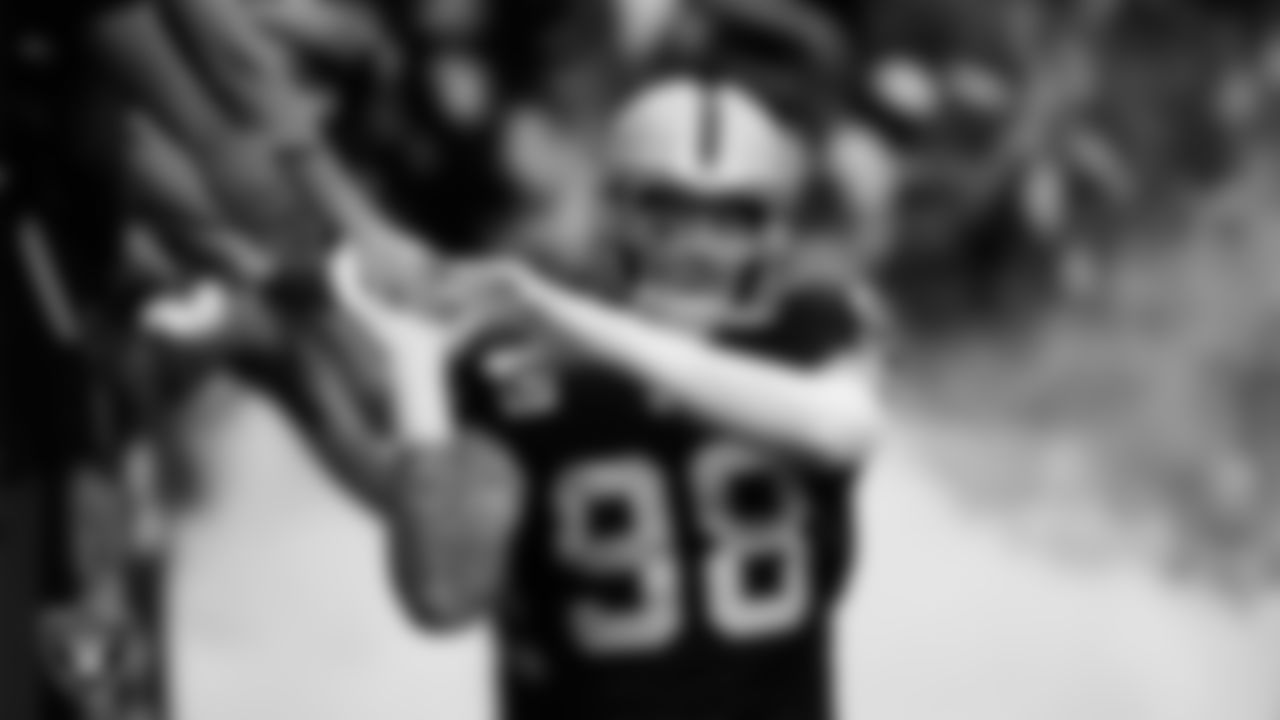 Las Vegas Raiders defensive end Maxx Crosby (98) high-fives fans before being introduced onto the field before the regular season home game against the Tennessee Titans at Allegiant Stadium.