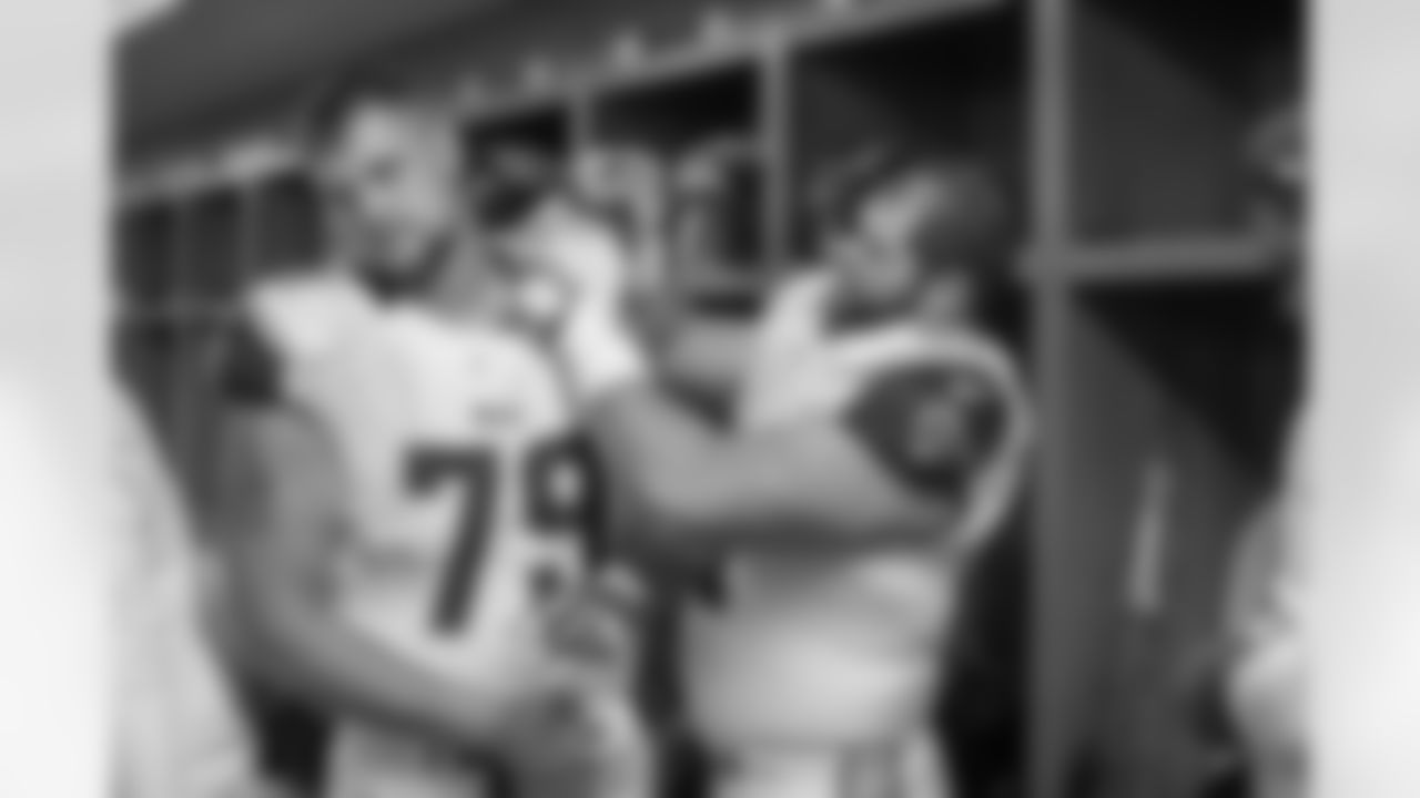 Center (61) Tim Barnes of Los Angeles Rams helps teammate (79) Rob Havenstein with his shoulder pads in the locker room before the Rams 28-31 loss to the Detroit Lions in an NFL Week 6 game at Ford Field, Sunday, October 16, 2016, in Detroit, MI. (Jeff Lewis/Rams)
