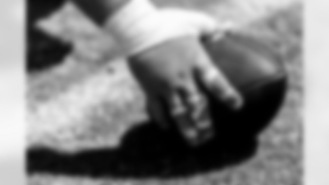 C Tyler Linderbaum's hand on a Football.