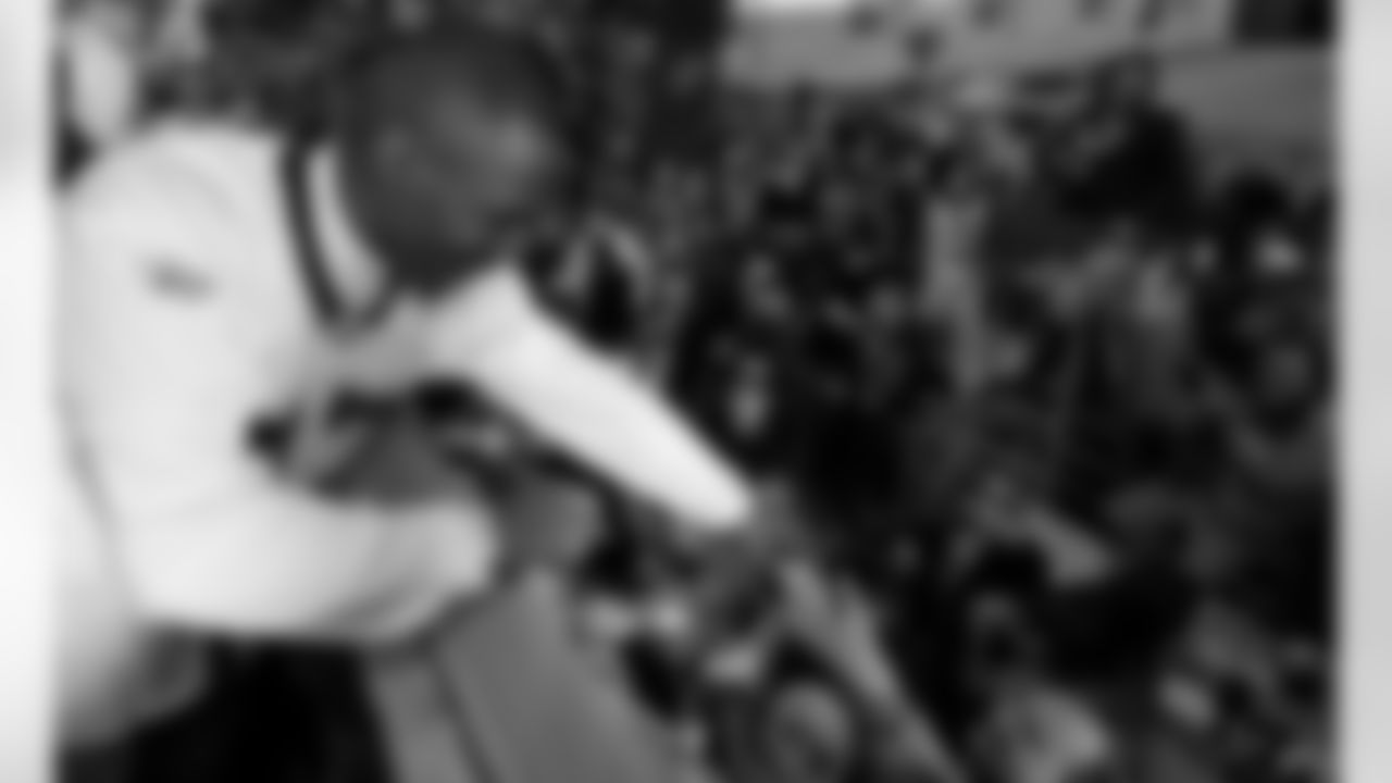 New Orleans Saints football receiver Joe Horn hands a can of beer down that a fan asked him to sign as he rides in the Krewe of Endymion during their Mardi Gras parade through the Uptown area of New Orleans, Saturday, Feb. 17, 2007.