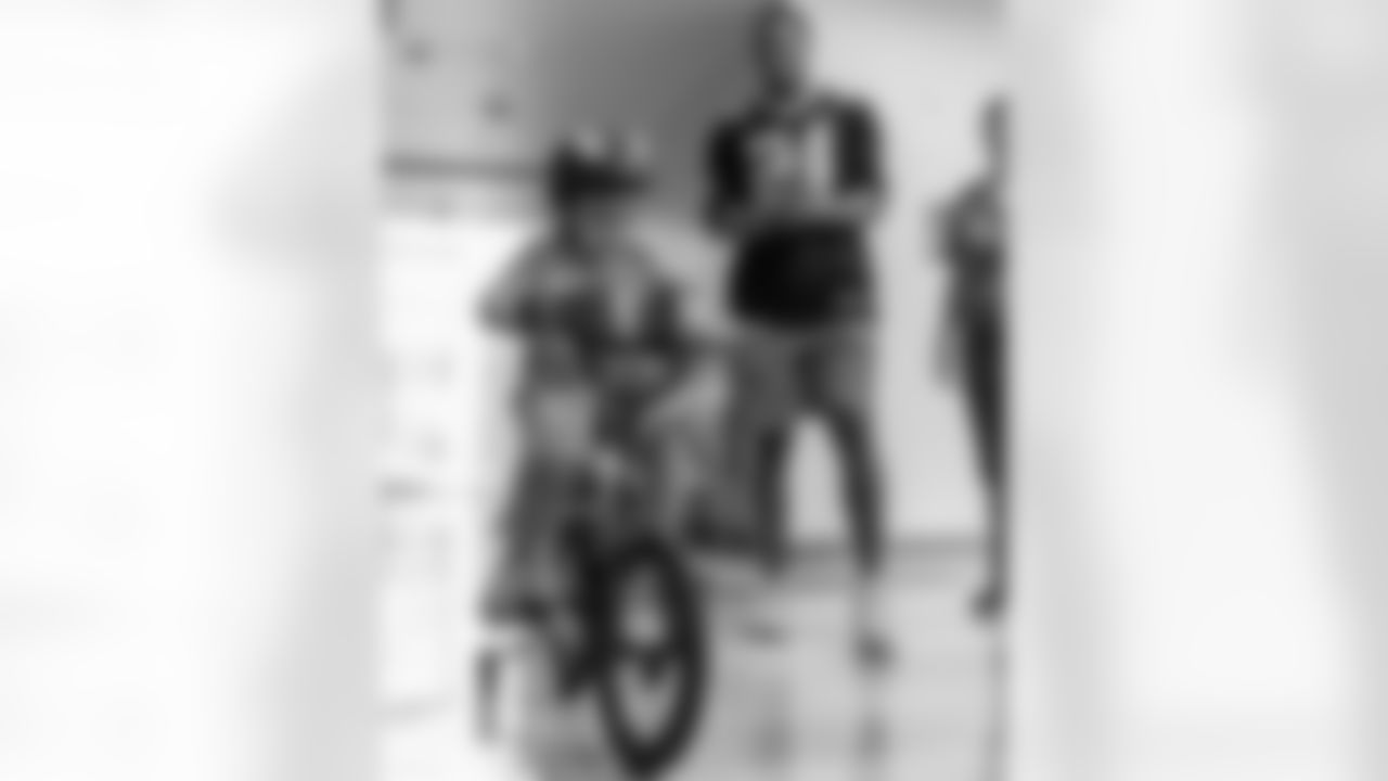 New Orleans Saints player Johnathan Abram drops off a gift of a Spiderman bike for Cecilo, a patient he met on Oct. 1, as Cecilo and his family threw their "No Mo Chemo" party to ring the bell and celebrate beating cancer at Ochsner Health's Center for Children on October 8, 2024 during the NFL's Crucial Catch month.