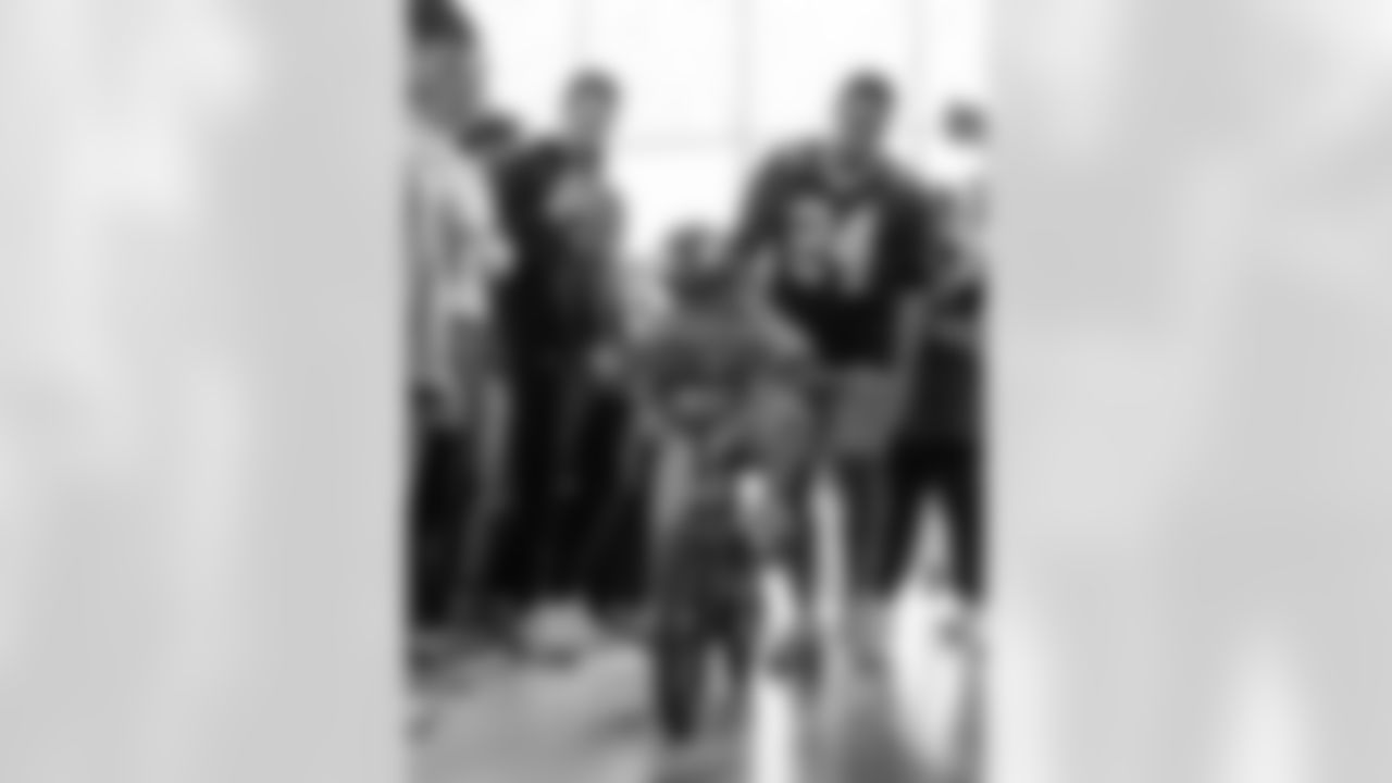 New Orleans Saints player Johnathan Abram drops off a gift of a Spiderman bike for Cecilo, a patient he met on Oct. 1, as Cecilo and his family threw their "No Mo Chemo" party to ring the bell and celebrate beating cancer at Ochsner Health's Center for Children on October 8, 2024 during the NFL's Crucial Catch month.