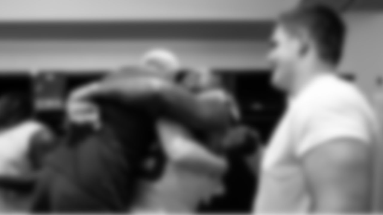 Seattle's Leonard Williams celebrates in the locker room by picking up assistant coach Kirk Olivadotti. At right is offensive guard Grey Zabel.