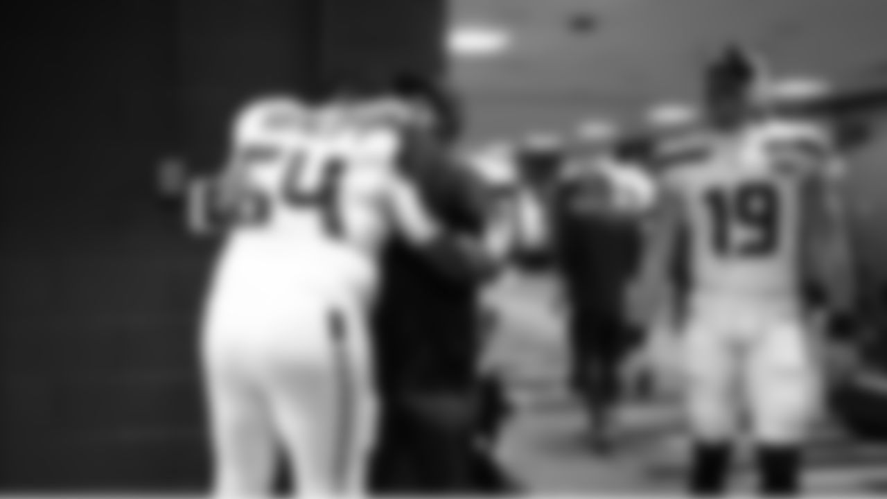 Seahawks team chaplain Jonathan Rainey with offensive lineman Christian Haynes in the locker room.