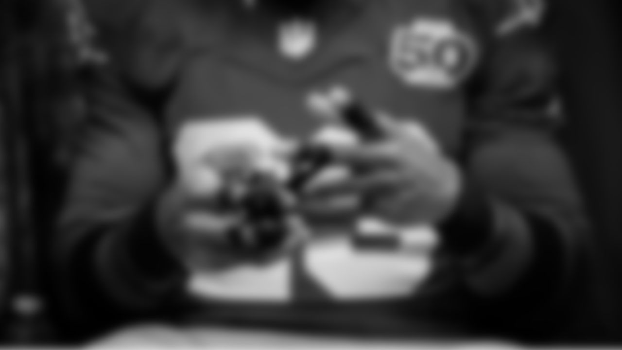 In the locker room, defensive back D'Anthony Bell tapes his fingers before the game.