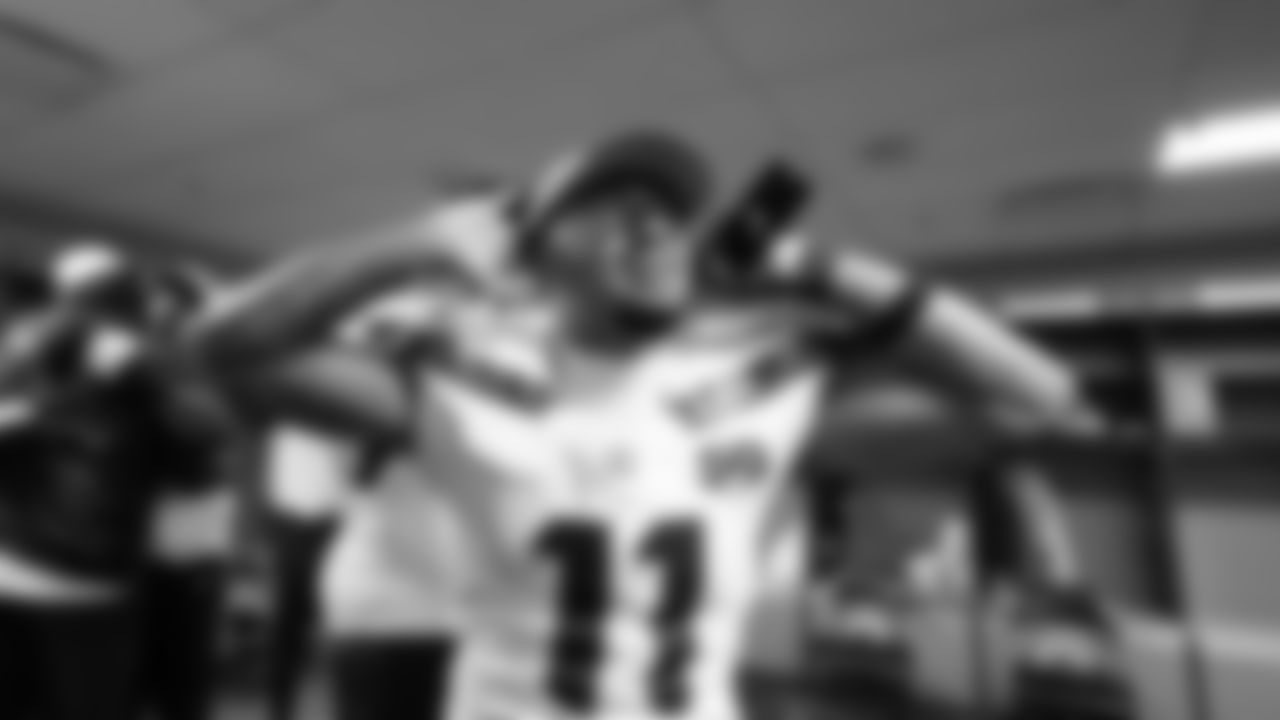 Receiver Jaxon Smith-Njigba dances in the locker room after the win.