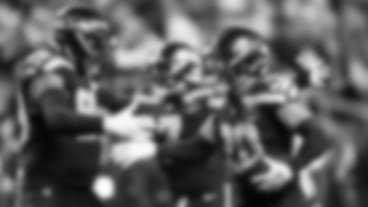 Seahawks safety Julian Love celebrates his fumble recovery with teammates Leonard Williams and Uchenna Nwosu.