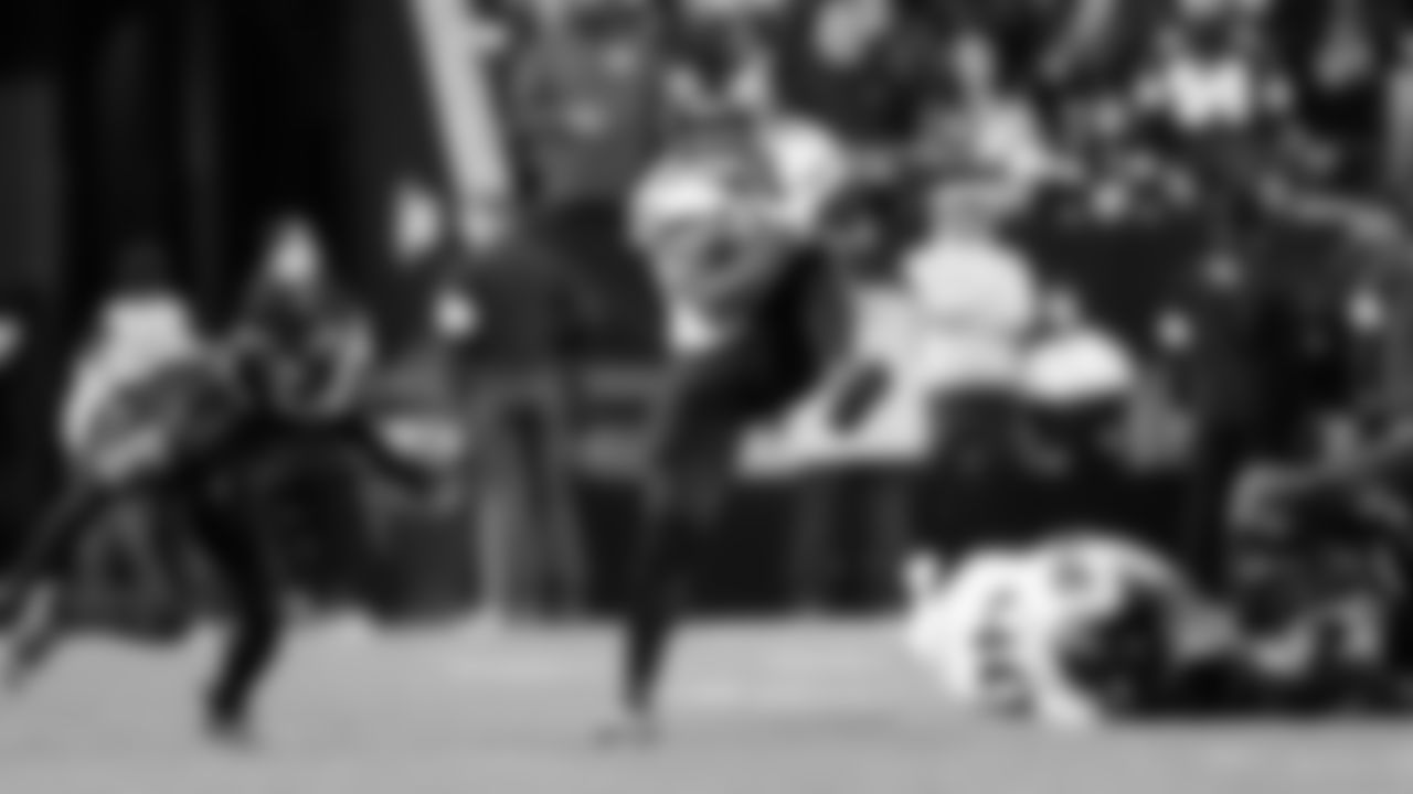 Seahawks running back Kenneth Walker III jumps through a hole.