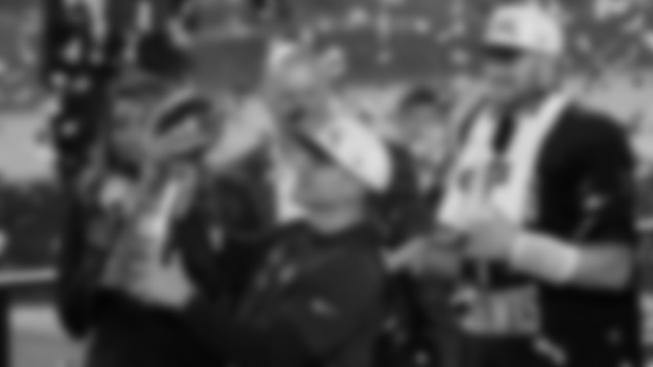 Seattle Seahawks head coach Mike MacDonald holds the trophy as quarterback Sam Darnold, right, and others look on after the team's win in the NFL Super Bowl 60 football game against the New England Patriots, Sunday, Feb. 8, 2026, in Santa Clara, Calif. (AP Photo/Charlie Riedel)