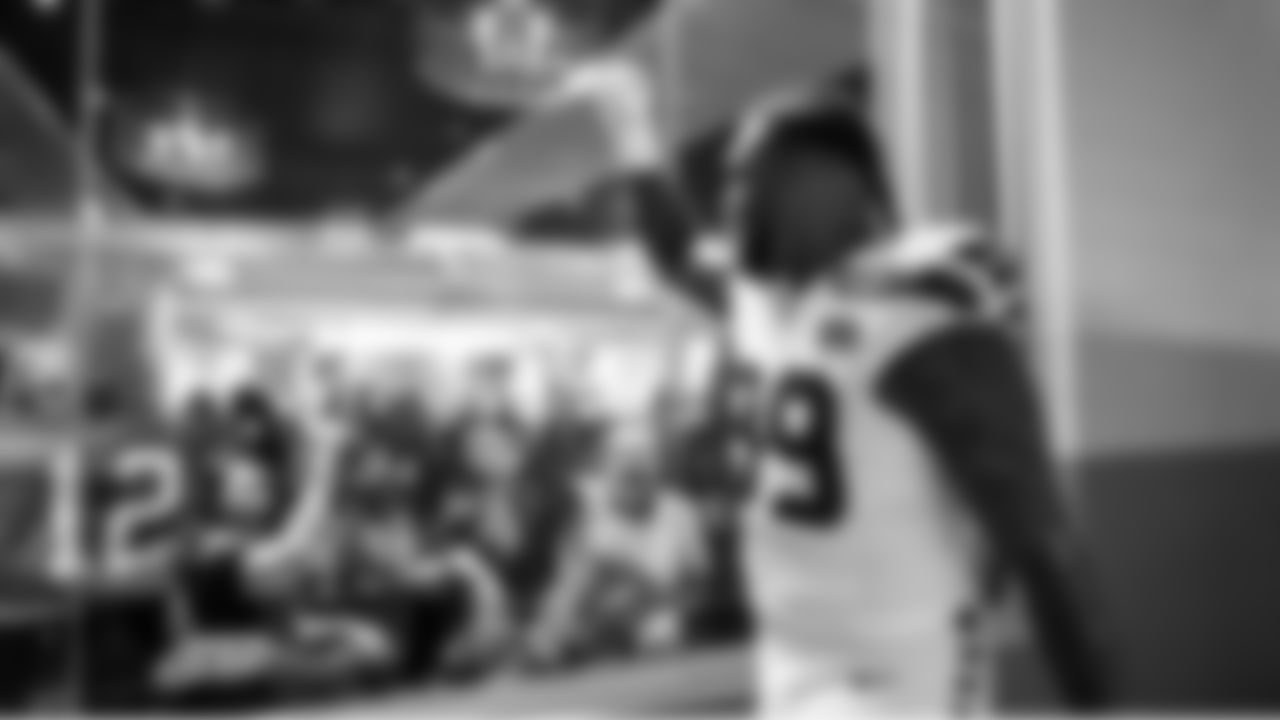 Seahawks defensive lineman Leonard Williams salutes 12s in one of the club lounges at Mercedes-Benz Stadium that offers a view of the visiting team walking to the field.