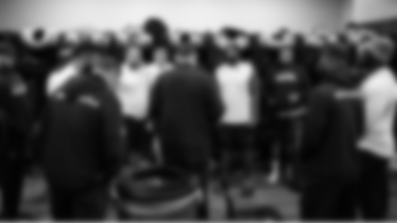 In the Seahawks locker room, offensive line coach John Benton talks to his players.