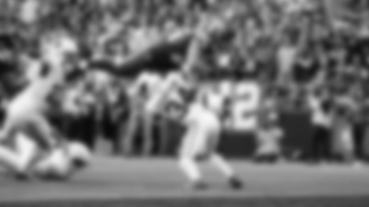 Seahawks running back Zach Charbonnet flies over a Cardinals defender for a touchdown.