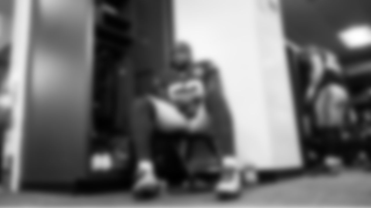 In the locker room, linebacker Boye Mafe sits near his locker waiting to head to the field for pregame warmups.