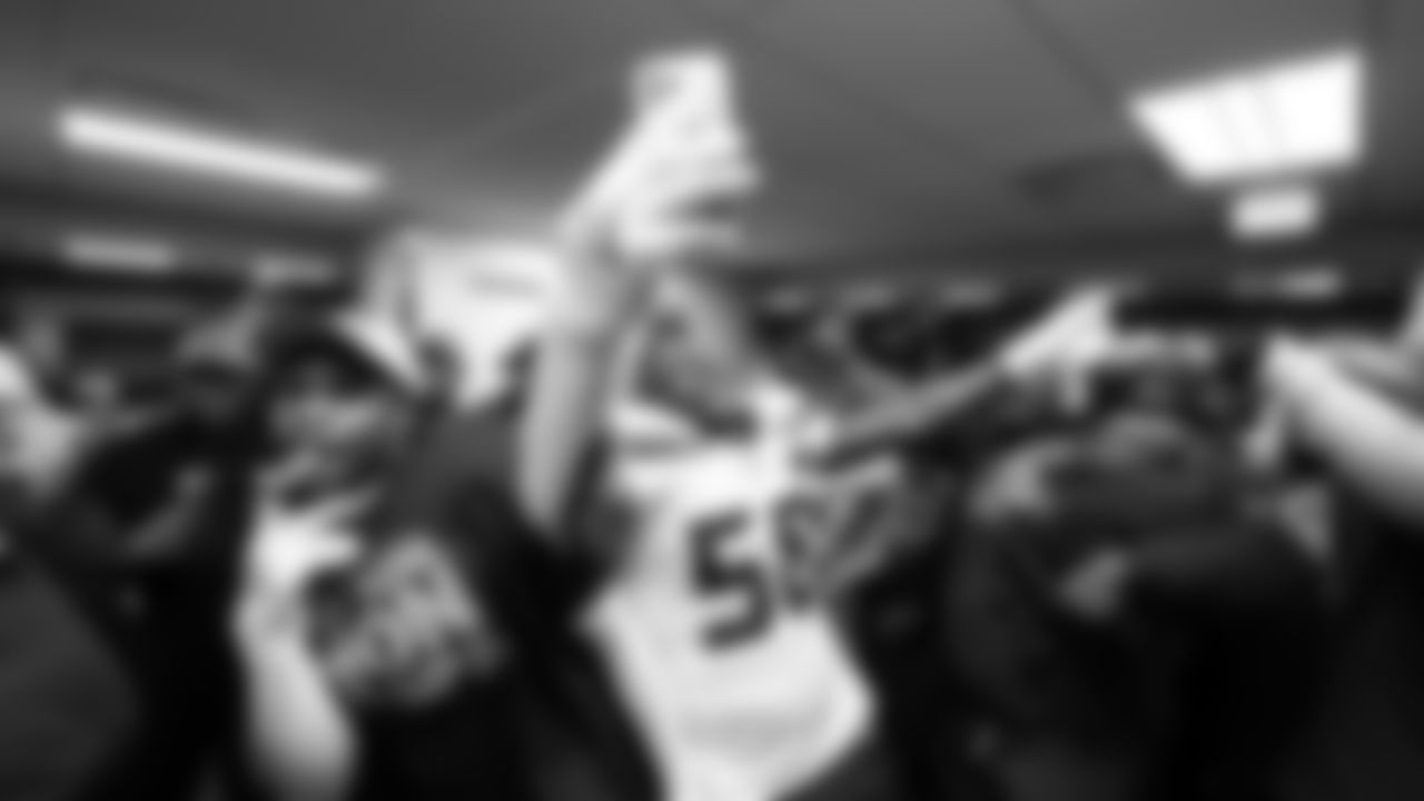 Derick Hall, Nick Emmanwori and teammates celebrate in the locker room.