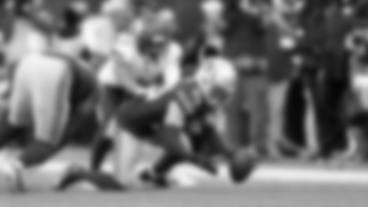 Seahawks safety Ty Okada recovers a fumble caused by teammate DeMarcus Lawrence.