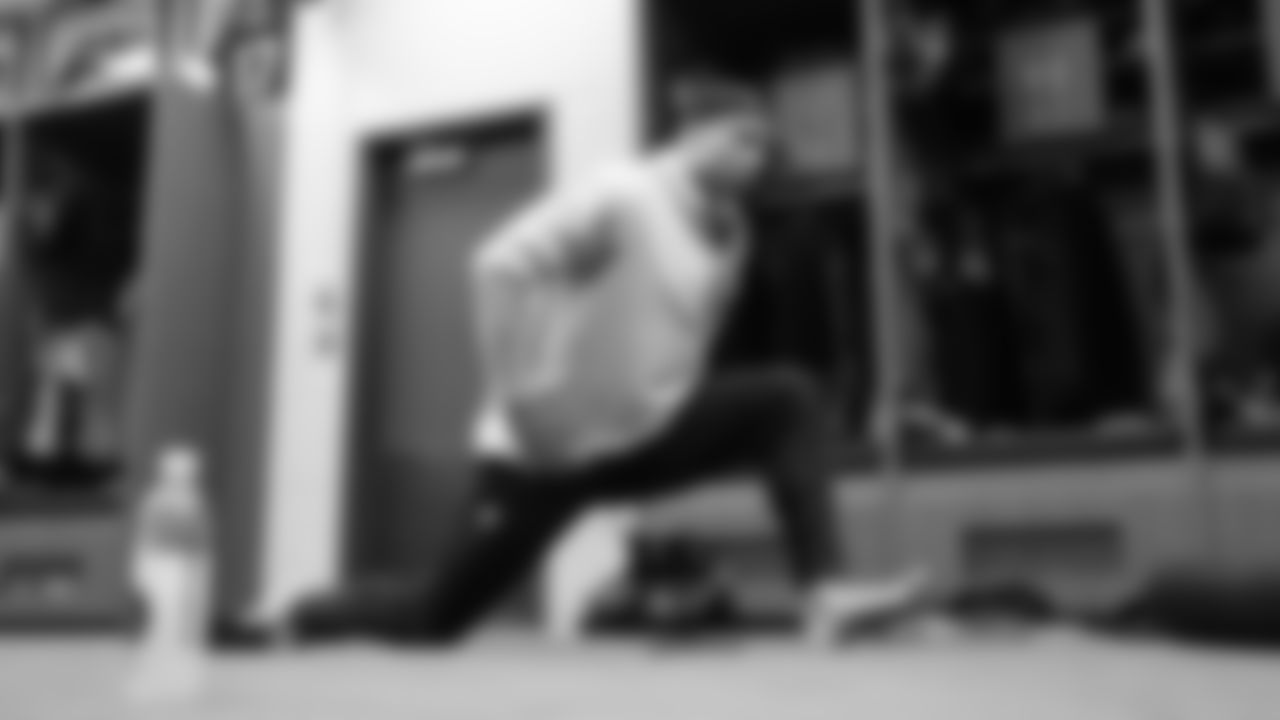 Running back Zach Charbonnet stretches in the locker room.