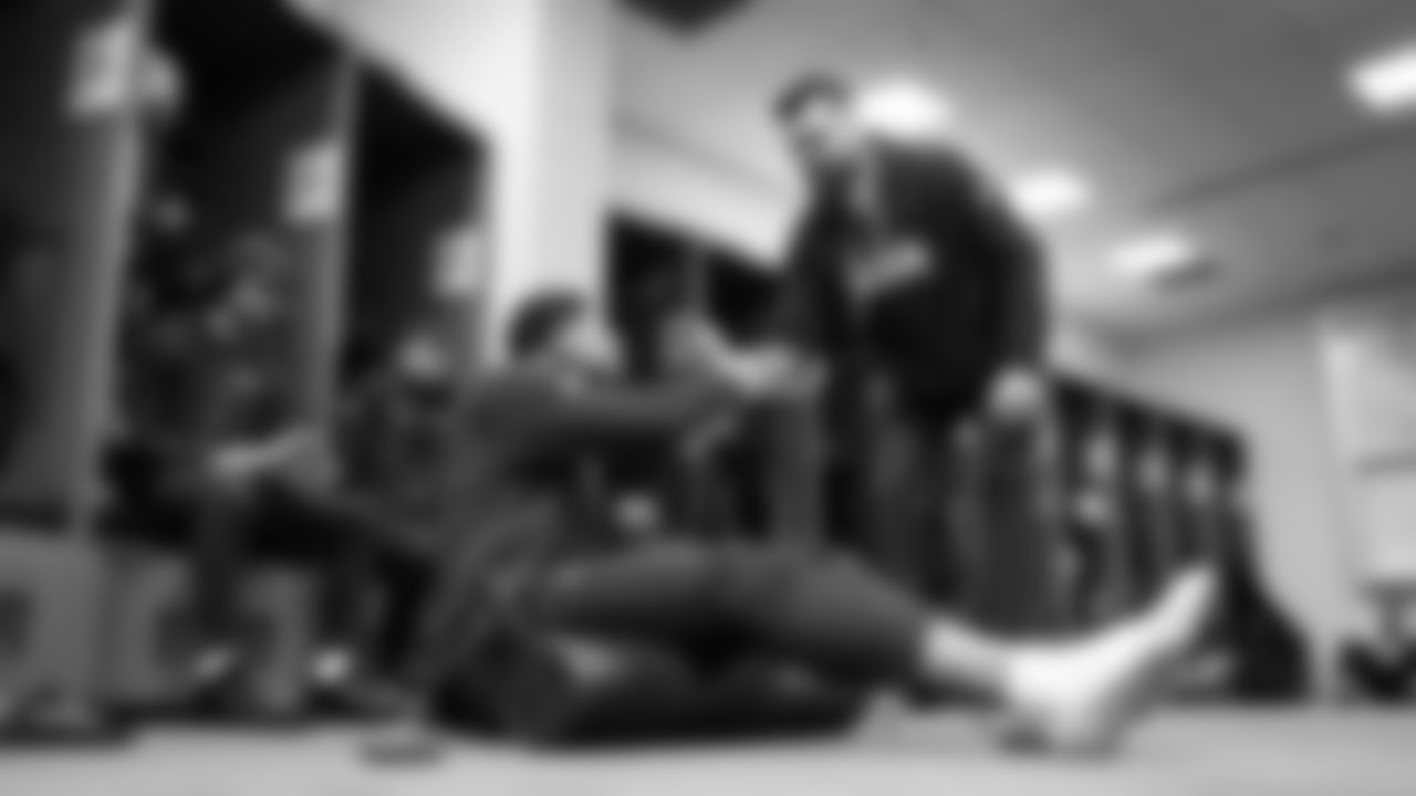 In the locker room, tight end Elijah Arroyo shakes hands with assistant coach Andrew Janocko.