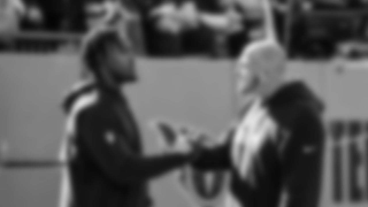 Outside linebackers coach Chris Partridge talks to linebacker Jamie Sheriff on the field during pregame.