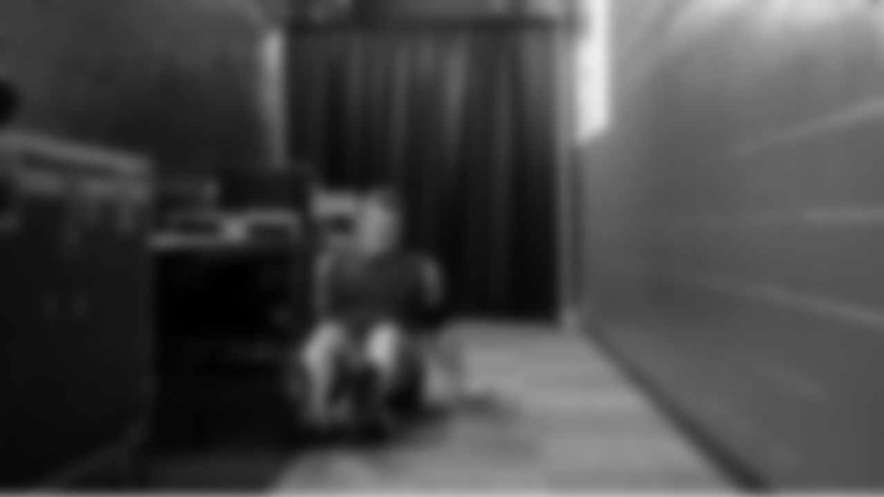 In an adjacent hallway, offensive lineman Mason Richman uses a foam roller to stretch.