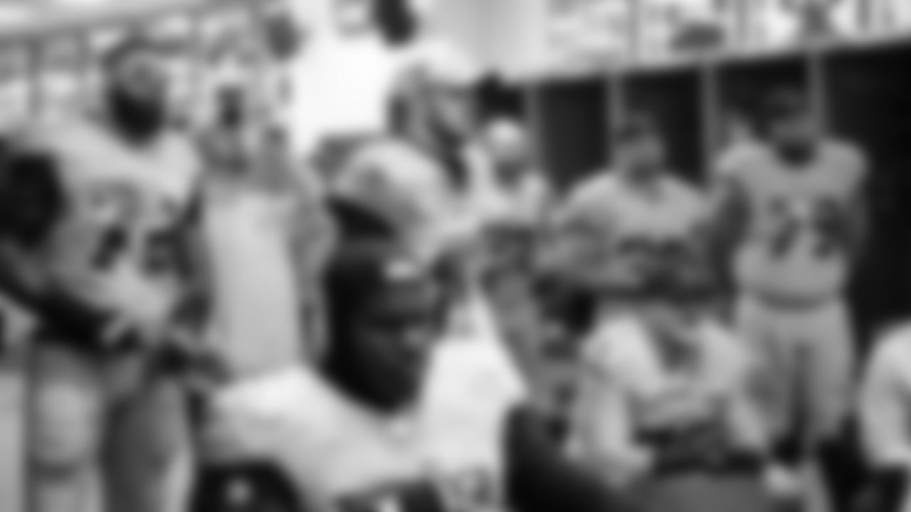 Members of the offense listen to instruction in the locker room at halftime.