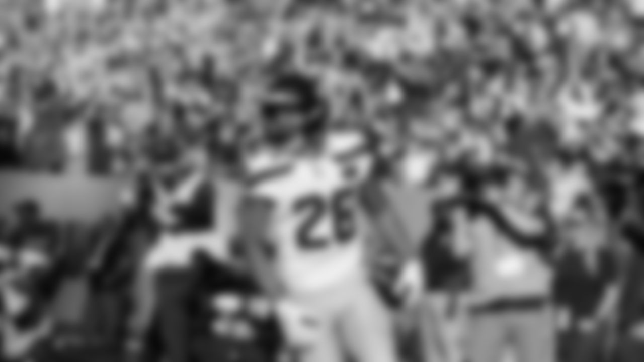 Seahawks running back Zach Charbonnet scores a touchdown as a huge crowd of 12s roar in the background,