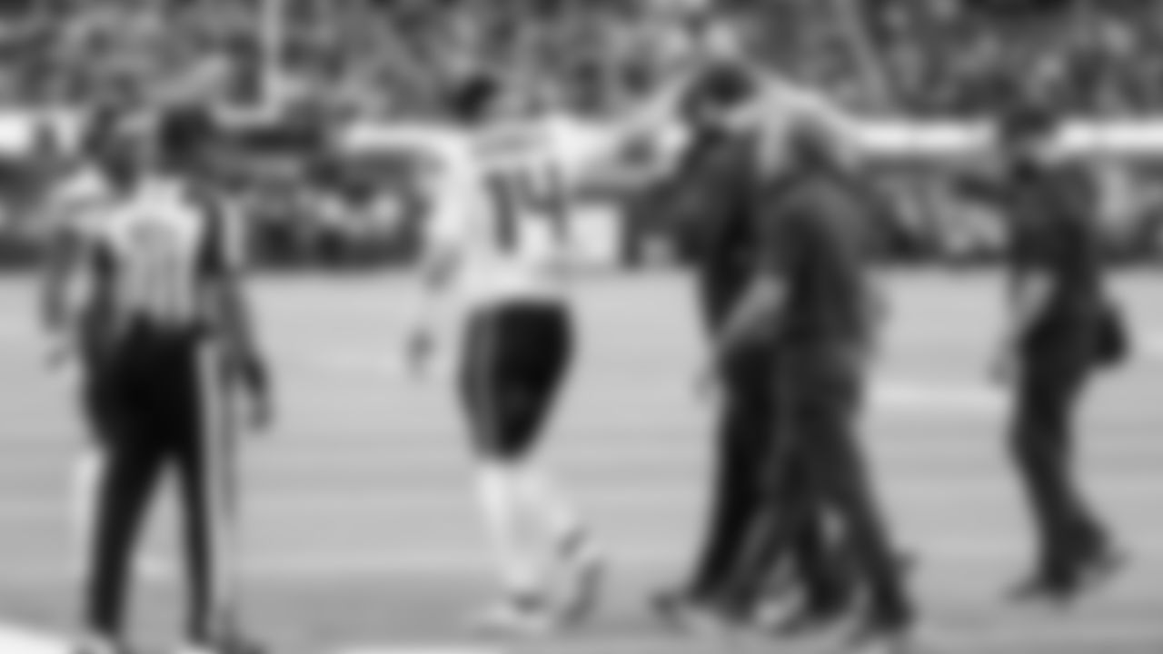 Seahawks quarterback Sam Darnold comforts injured offensive guard Grey Zabel, who is helped off the field.