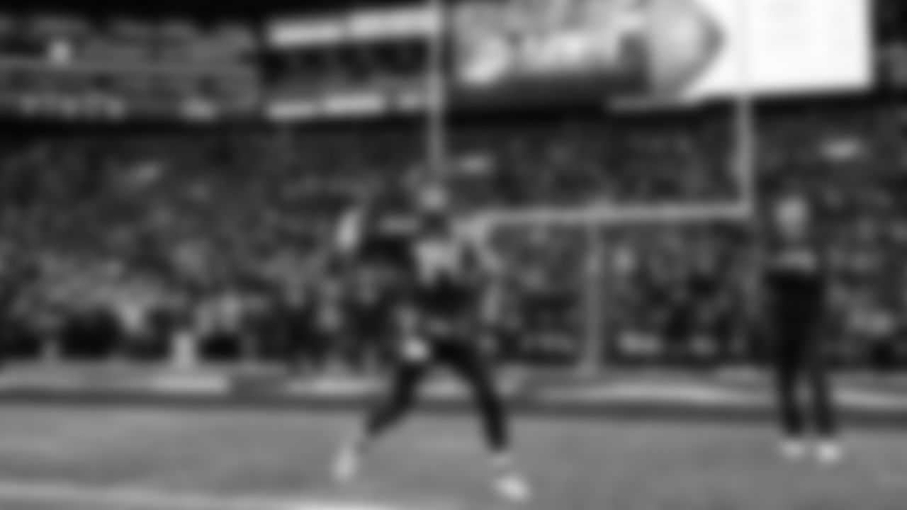 Seahawks quarterback Sam Darnold takes warmup throws as quarterbacks coach Andrew Janocko looks on.