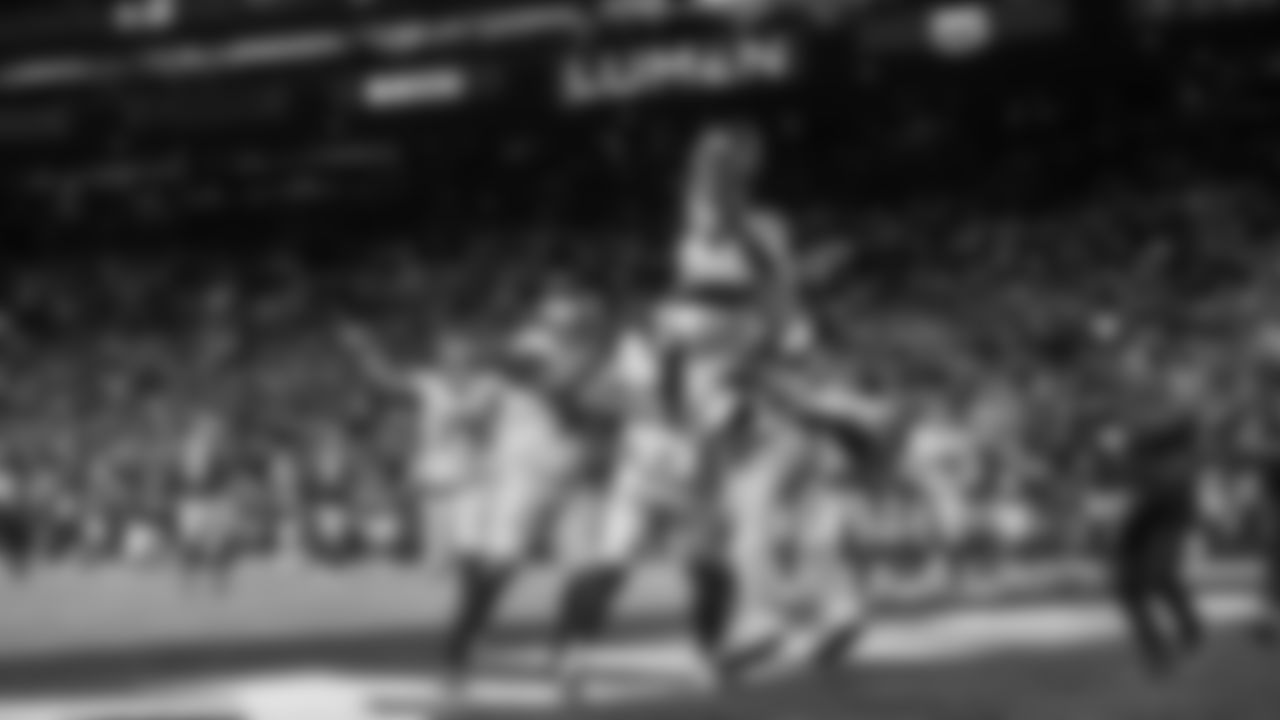 The Seahawks, including AJ Barner who leapt high into the pile, celebrate with Eric Saubert after his catch provided the game-winning two-point conversion.