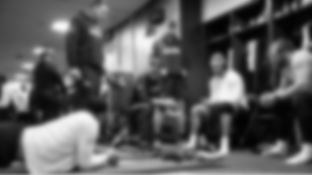 Tight end coach Mack Brown meets with his players in the locker room before the game.