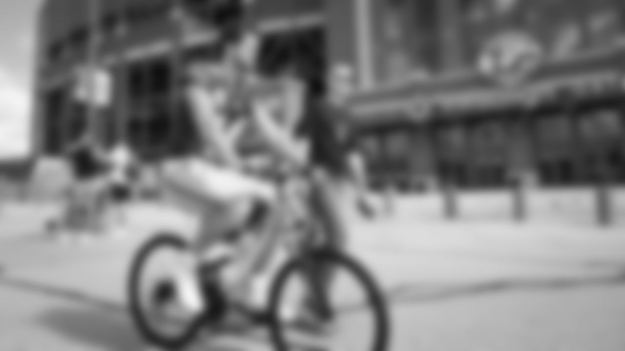 Seahawks quarterback Sam Darnold (14) rides a bike on their way to practice on August 21, 2025 in Green Bay, Wisconsin.