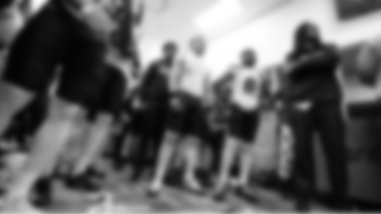 Seahawks players listen as head coach Mike Macdonald talks to them in the locker room after the game.